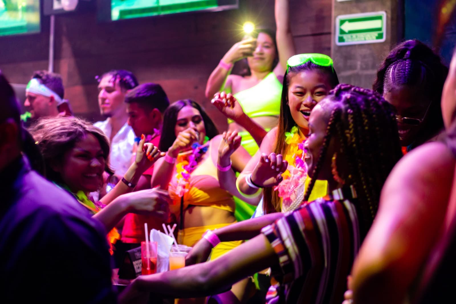 Crowd dancing under neon lights on a club night